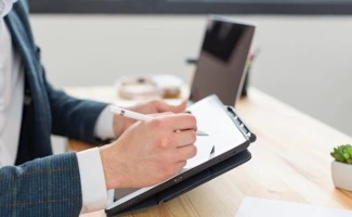 Unas manos de hombre puntean resultados en una lista de verificación