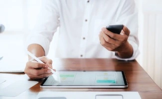Un profesional se enfrenta a su mesa de trabajo repleta de facturas y papeles.