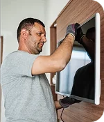 imagen de un técnico instalando un televisor