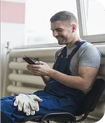 imagen de un fontanero sonriente consultando su movil